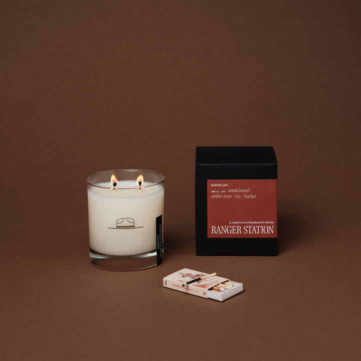 Candle with matches and packaging on a brown background