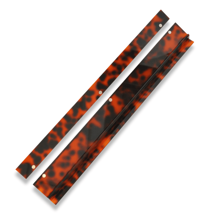 Tortoise shell mahjong rack and pusher on a white background.