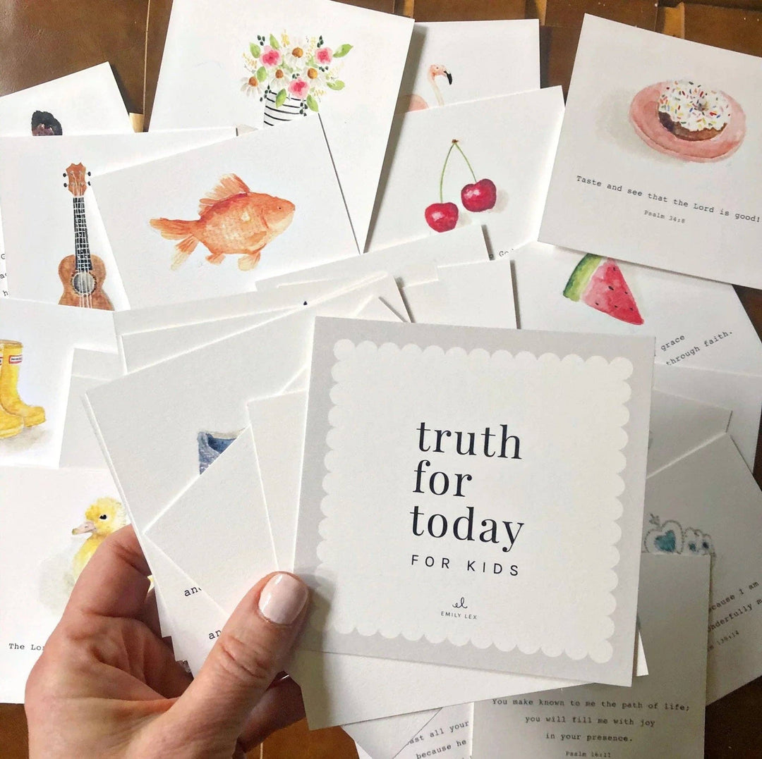 Collection of small cards with various illustrations and a hand holding one card.