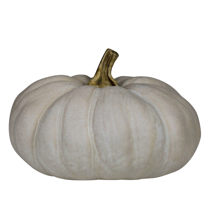 A decorative faux pumpkin in a warm off-white or cream color with a textured surface and a metallic gold stem, isolated on a white background.
