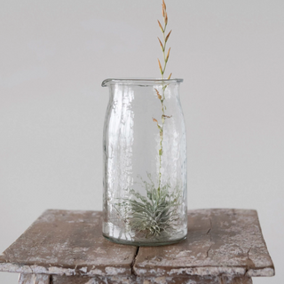 This pitcher exudes both simplicity and class. Made out of hand-blown glass, this can be used for serving guests, for display on a countertop, or for storing small decorative items. (4" Round x 7-1/2"H 36 oz)